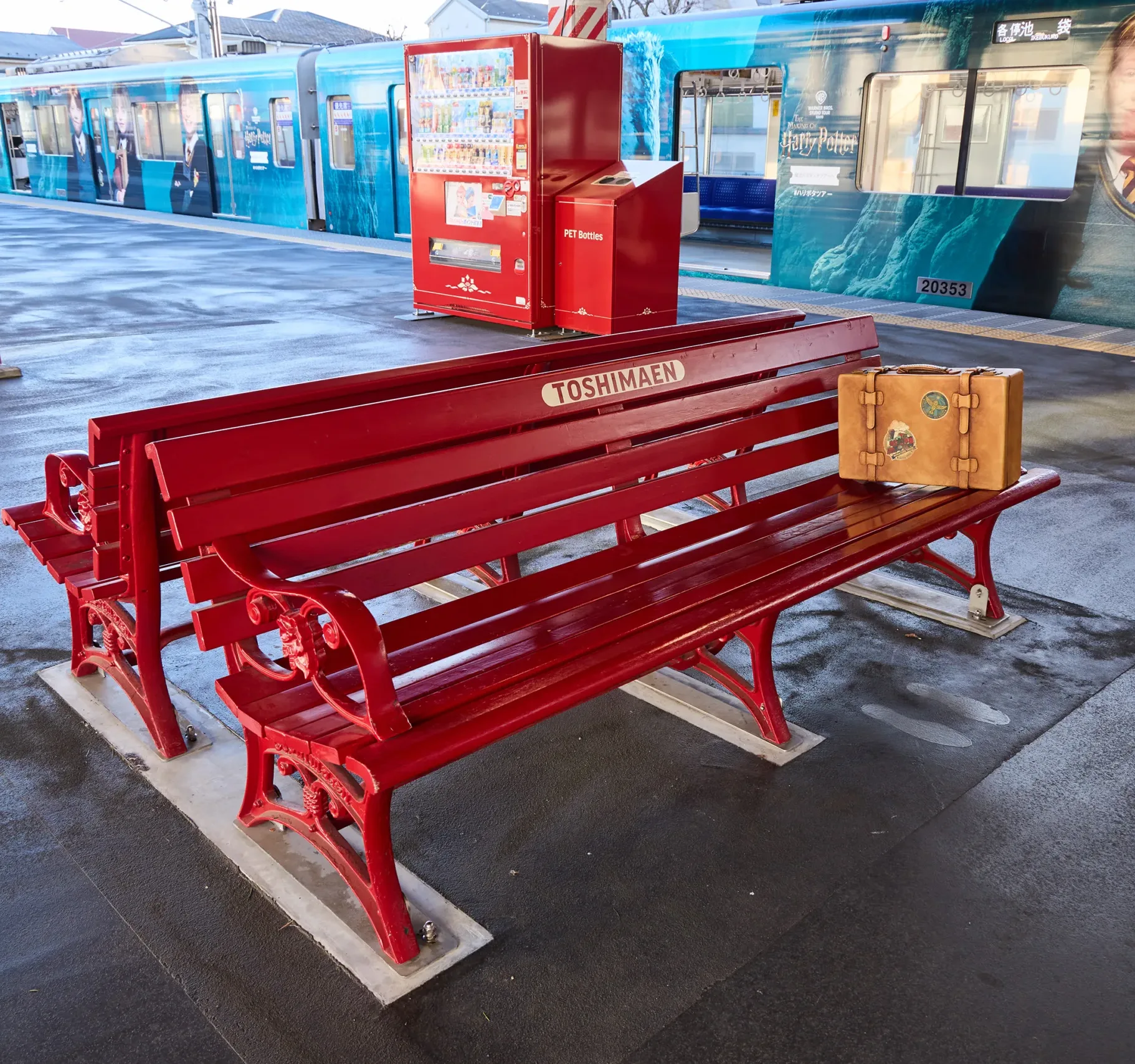 豊島園駅ホームの赤いベンチとラッピング電車が、スタジオツアー東京の玄関口らしいホグズミード駅風の世界観を表現している